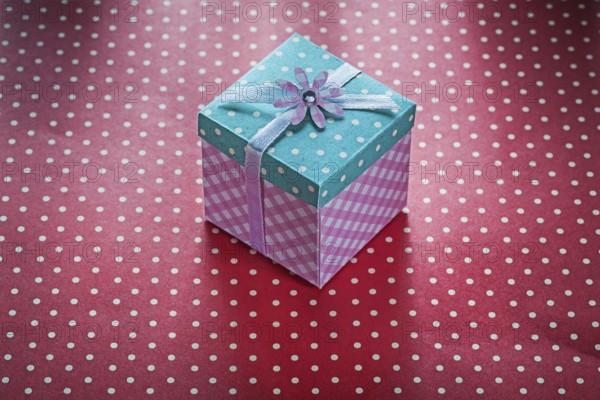 Present box on red polka-dot table cloth celebrations concept