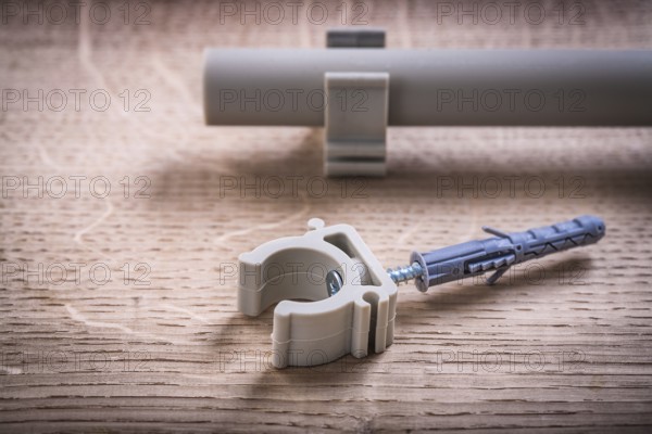 Close Up Pipe With Clips And Polypropylene Fixator On Wooden Board
