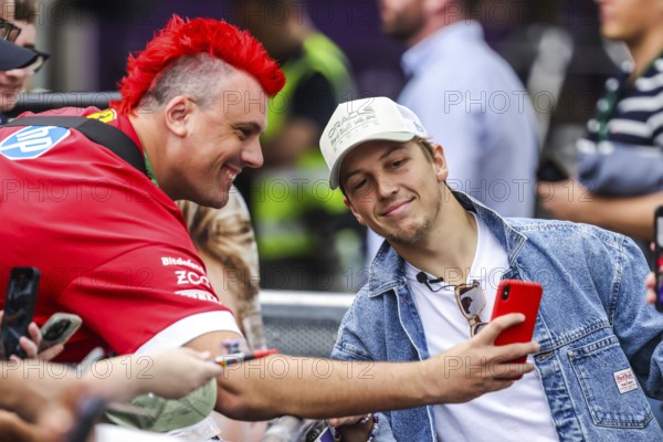 MELBOURNE, AUSTRALIA - MARCH 13: Liam Lawson of New Zealand and Oracle Red Bull Racing with fans before the 2025 Australian Grand Prix at Albert Park in Melbourne, Australia