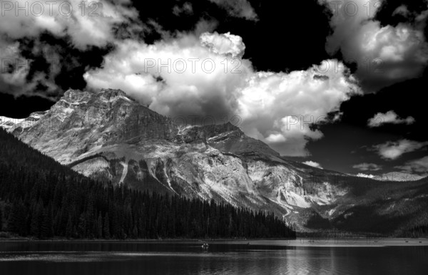 A dramatic black and white landscape with the Canadian Rocky Mountains and Emerald Lake under a cloudy sky as seen inside of Yoho National Park, Alberta, Canada, North America