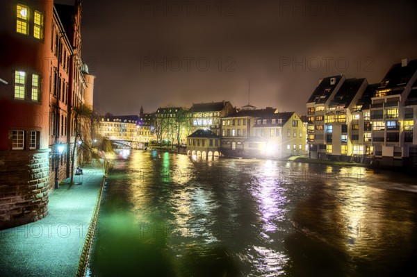 Scenic view View on river in Strasbourg, France at night. Romantic lights reflecting on the water and traditional houses and buildings all around