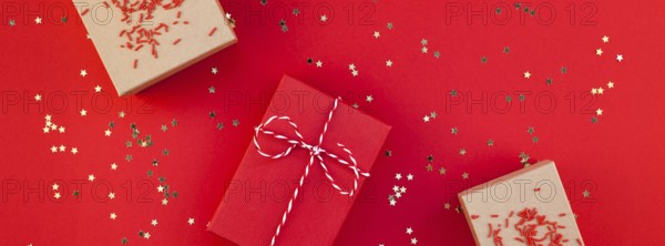 New Year or Christmas presents wrapped ribbon flat lay top view Xmas holiday 2019 celebration handmade gift boxes red paper golden sparkles background. Template mockup greeting card long wide banner