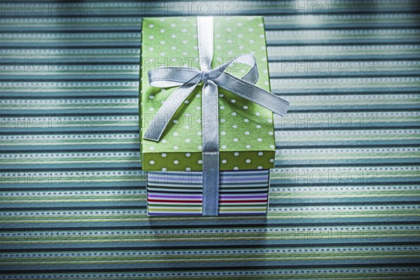 Present box on striped background holidays concept