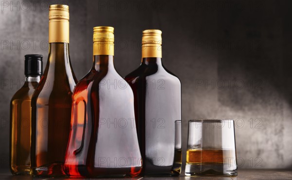 Composition with glass and bottles of assorted alcoholic beverages