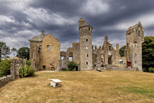 Historic castle with towers and dramatic sky on a lawn, Gratot Castle in Normandy, France