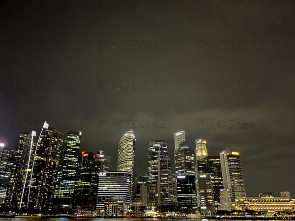 Illuminated skyline of a city at night with high skyscrapers and a dark sky, singapore, aisia