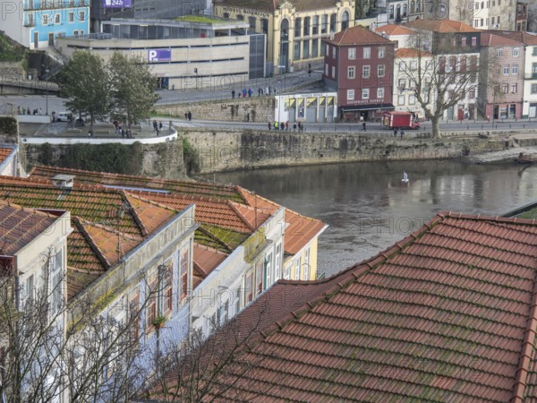 View over red roofs to the river and lively streets with beautiful old buildings in the background, porto, portugal
