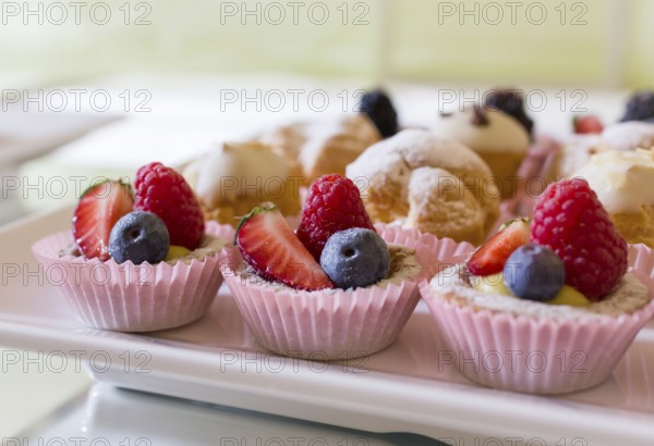 Close up of fresh and tasty cakes with fruits and berries