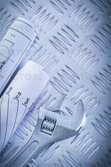 Engineering drawings monkey wrench on corrugated metal sheet construction concept