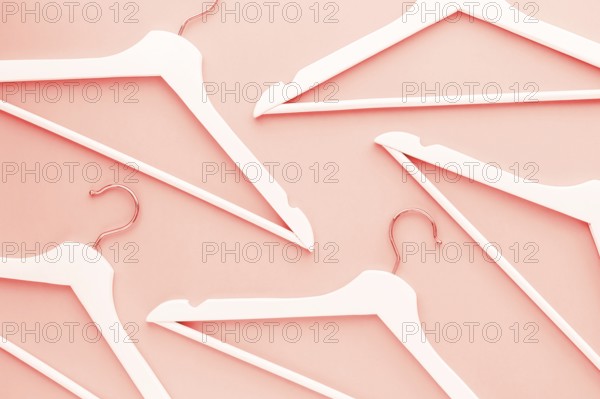 Creative top view flat lay wooden hangers toned living coral color of the year 2019 background copy space minimalism style. Template fashion blog social media sale store promo design shopping concept