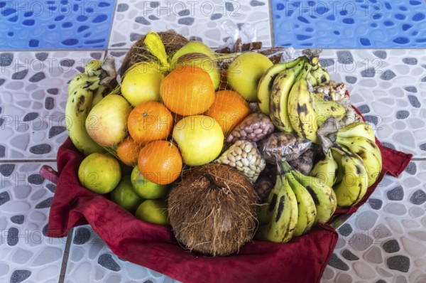 Colorful fresh fruits mixed in the basket lay on the tiling