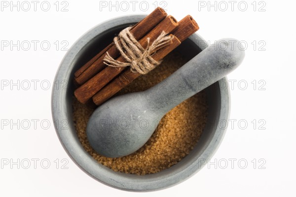 Cinnamon sticks with pure cane brown sugar in mortar