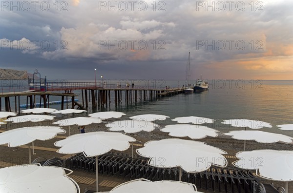 View of evening sunset sky from the empty beach of the resort town of Sudak. Crimea