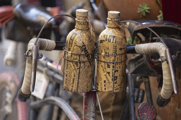 Two retro bottles attached to an old bicycle handlebar, at the legendary L'Eroica cycling race, Torrenieri, Tuscany, Italy