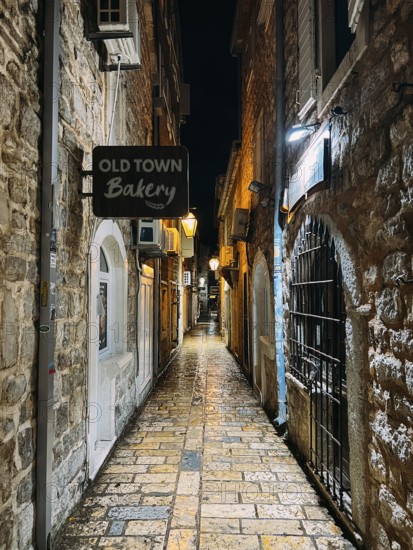 Budva, Montenegro - 25 december 2022: Signboard on a narrow street with stone houses. Caption: Old Town Bakery