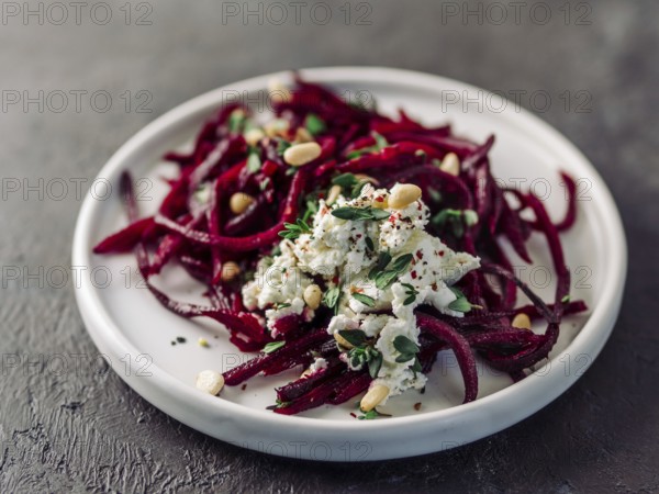 Raw beetroot spaghetti salad with soft cheese, nuts, thyme. Vegetable noodles - Fresh Beetroot Noodles with Ricotta and fresh thyme on plate. Copy space. Clean eating, raw vegetarian food concept