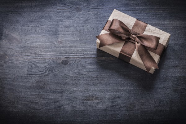 Present box-container with bow on vintage wooden board