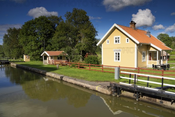 Yellow wooden building at Norrqvarn lock along the Gota Canal near the Swedish village Lyrestad