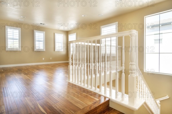 Large empty room with wood floor, molding and windows and stairs. Modern bright room, interiors