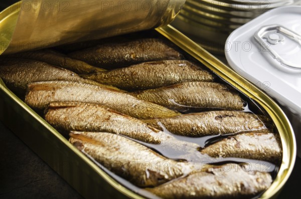 Canned smoked fish sprats in just opened tin can. Non-perishable food