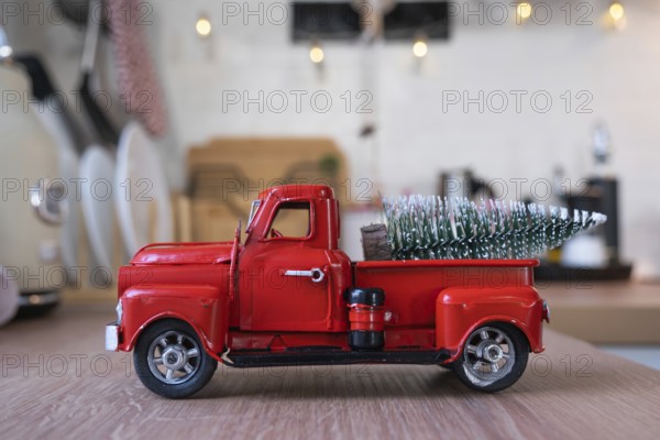 A red retro car with a Christmas tree decorates the festive kitchen for Christmas. Home decor, festive mood, New Year