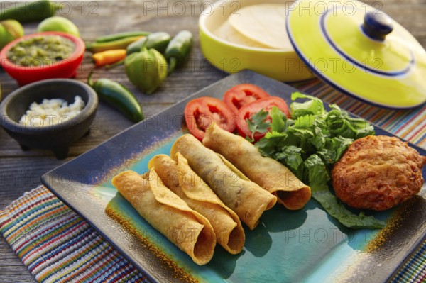 Mexican flautas rolled tacos with salsa and Mexico food ingredients