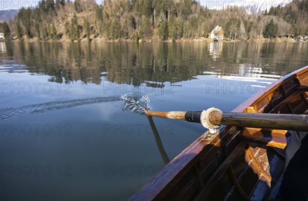 Young woman using paddle on a wooden boat, Lake Bled Slovenia rowing on wooden boats on a sunny day
