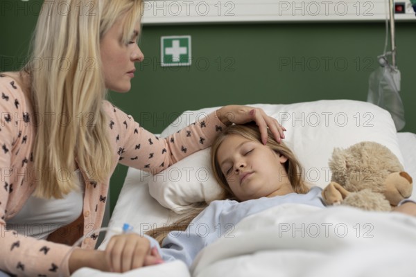 A devoted mother cares for her sick child in the hospital, showing unconditional love and unwavering support