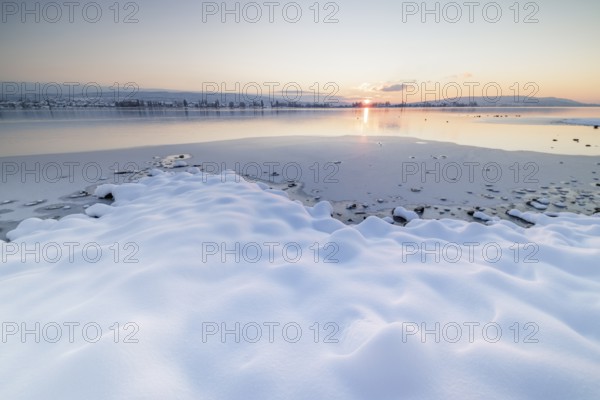 Winter landscape with a frozen lake at sunset, soft snow cover and reflecting water, Seegarten, Allensbach, Lake Constance, Baden-Württemberg, Germany