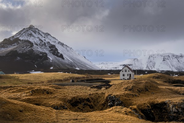 Lonely house on the basalt coast and Stapafell mountain near the snfellsjoekull glacier, Arnarstapi, Snaefellsnes, Iceland