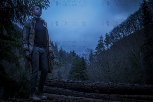 Young man in the forest at night. Early morning