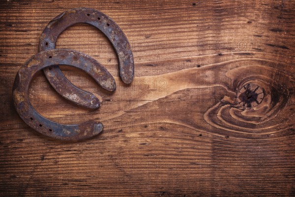 Two horseshoe on vintage wooden board close up happy concept