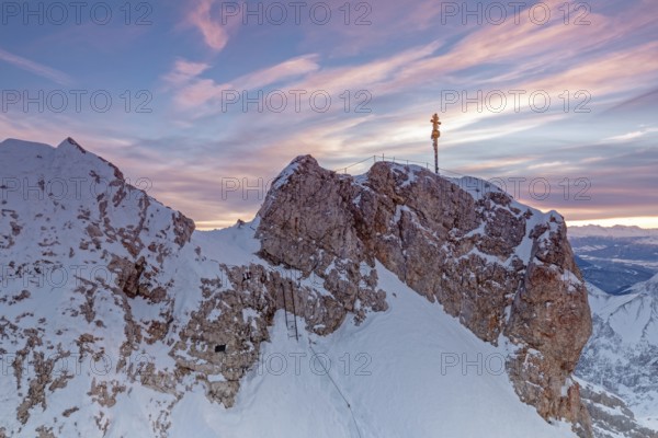 Daybreak on the summit of the Zugspitze with summit cross