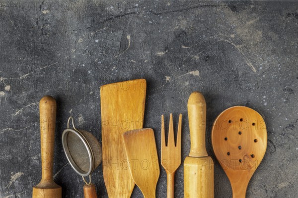 Set of wooden kitchen utensils on a blue background, copy space