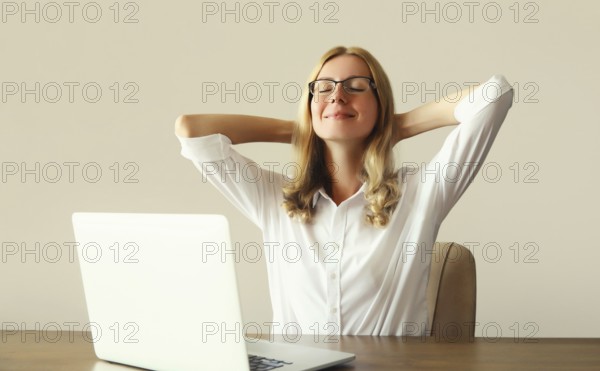 Relaxed happy young woman take a break meditates working with laptop sitting at desk in office or home