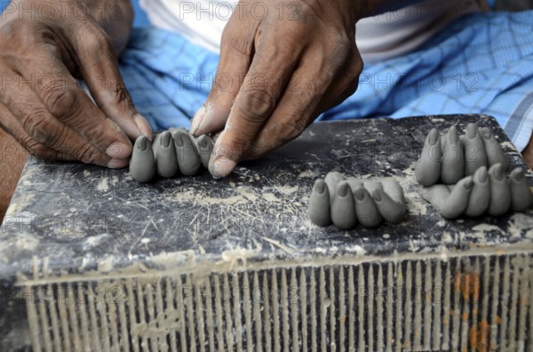 Man making fingers of clay, Kumartuli, Kolkata, West Bengal, India, Asia