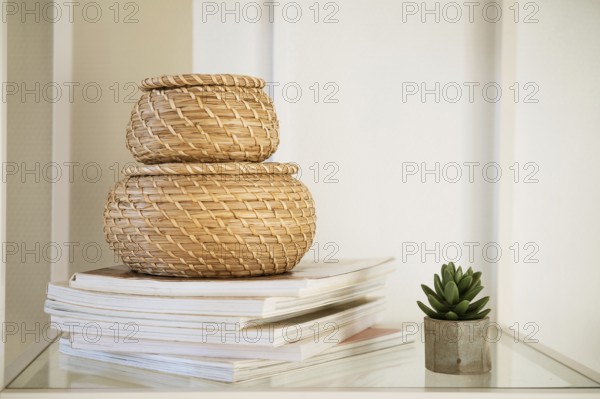 Close-up of a round straw box with a lid on a white shelf. Eco-friendly items for storing small items, organising space. Home decor decorative items. Stand on a shelf in the room