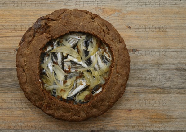 Traditional Finnish rye pie with vendace on a wooden table