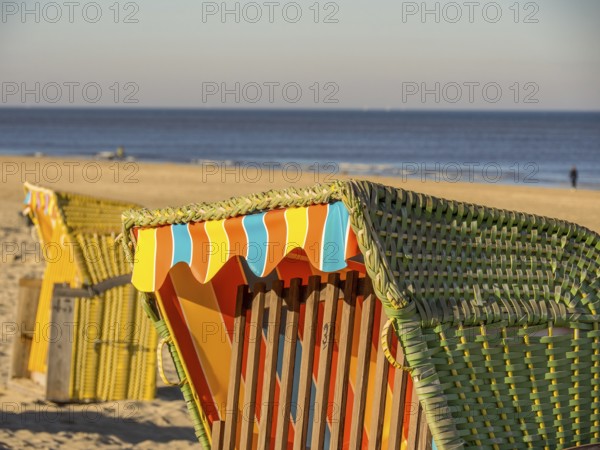 Close-up of a colourful beach chair on a sandy beach, overlooking the calm sea under a clear blue sky, egmond aan zee, the netherlands
