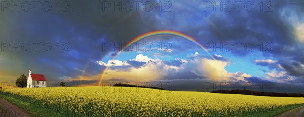 Panorama, chapel and rainbow over a rapeseed field