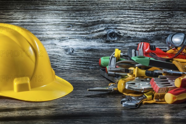 Construction helmet and set of tools on vintage wood