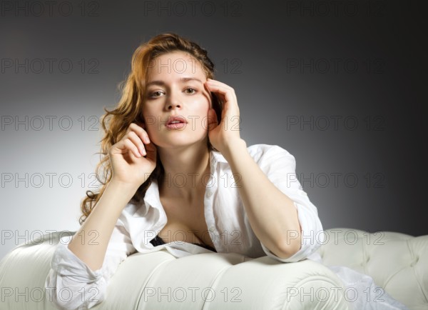 Beauty fashion portrait. Beautiful young woman on grey wall background