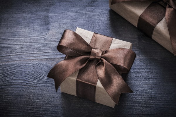 Present boxes with tied ribbons on wood board holiday concept