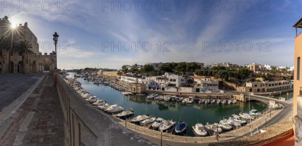 Ciutadella, Spain, 26 January, 2024: view of the Ciutadella town hall and the harbor and fisherman's district with a sunstar