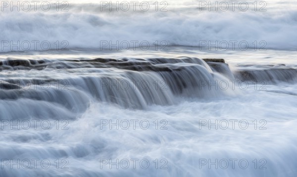 Rocky seashore with wavy ocean and waves crashing on the rocks at Akrotiri coast area in Limassol, Cyprus