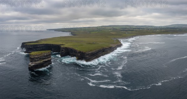A panorama landscape view of the wild and rugged coastline of County Mayo in Ireland with the Downpatrick Head sea stack in the foreground