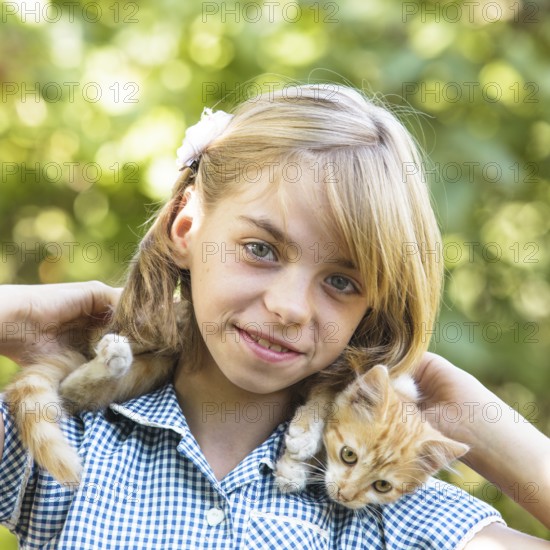 Girl play with kitten outdoor in the park