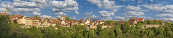 Panoramic view of the historic old town of Rothenburg ob der Tauber in sunny weather and clear clouds, with the towers and the wall of the historic town fortress, Rothenburg ob der Tauber, Germany