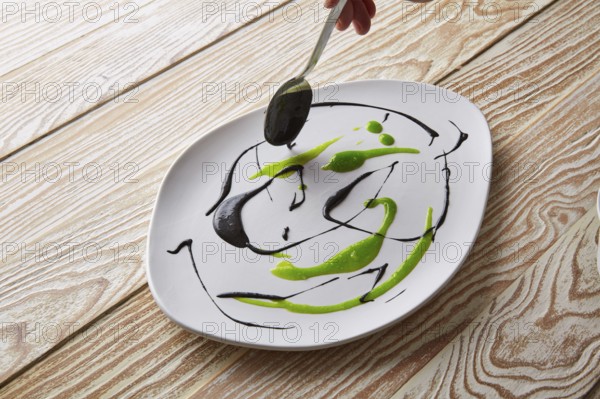 Modern cuisine chef preparation with creamy spots Molecular gastonomy