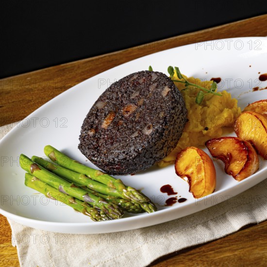 Black pudding with green asparagus and roasted apple